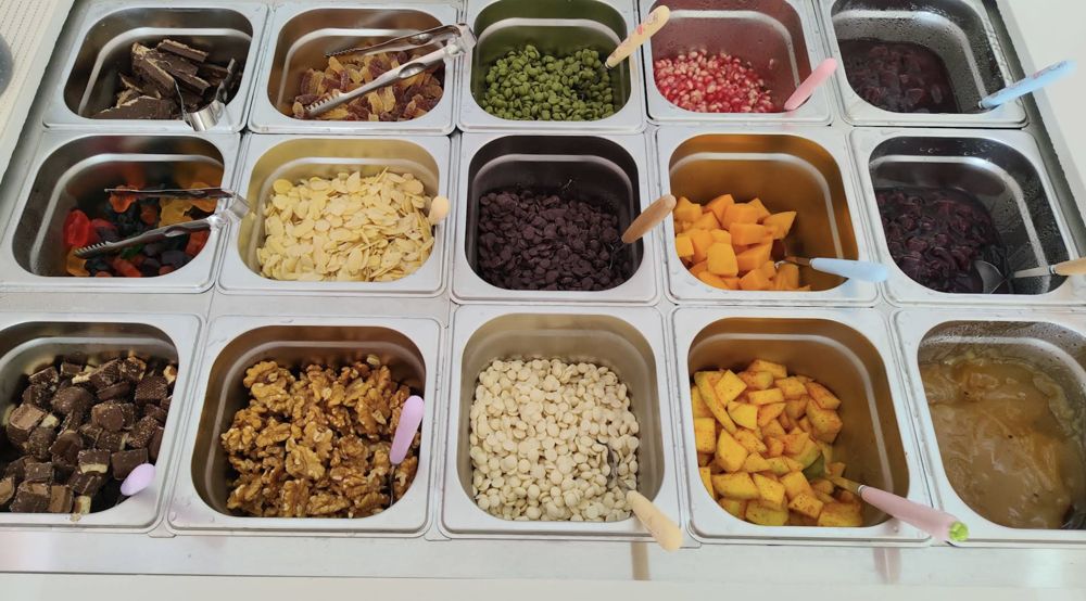 Toppings bar with nuts, mango, pomegranate and chocolate